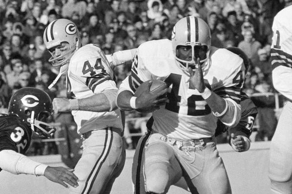 FILE - Green Bay Packers running back John Brockington (42) carries for a first down, past teammate Donny Anderson (44) and Chicago Bears cornerback Charlie Ford (32) during the third quarter of an NFL football game Nov. 7, 1971, in Chicago. Brockington, a former All-Pro fullback who ranks fourth on the Packers’ career rushing list, has died. He was 74. The Packers announced Brockington died Friday, March 31, 2023, in San Diego. (AP Photo/Fred Jewell, File)