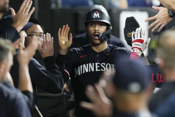 Minnesota Twins' Carlos Correa celebrates in the dugout after scoring when Matt Wallner reached on a fielding error by Chicago White Sox first baseman Andrew Vaughn during during the eighth inning of a baseball game, Saturday, Sept. 16, 2023, in Chicago. (AP Photo/Erin Hooley)