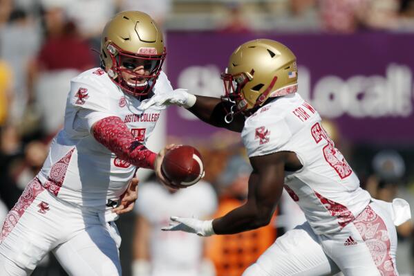 Boston College quarterback Phil Jurkovec (5) passes off to running back Alec Sinkfield (26) during the first half of an NCAA college football game against Massachusetts, Saturday, Sept. 11, 2021, in Amherst, Mass. (AP Photo/Michael Dwyer)