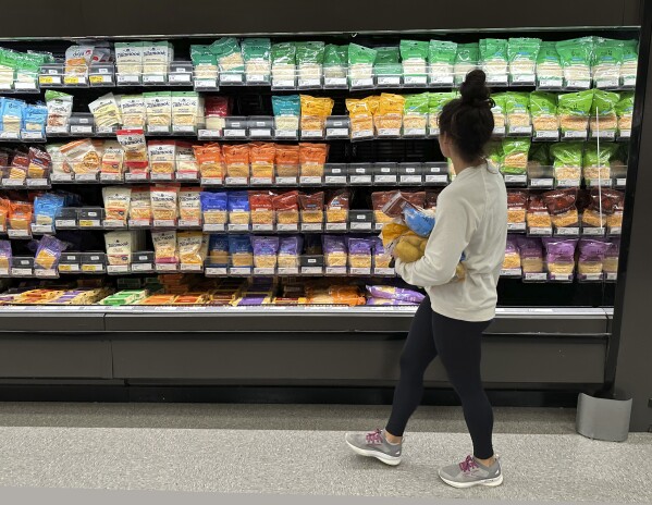 FILE - A shopper peruses the refrigerated cheese offerings in a Target store Oct. 4, 2023, in Shridan, Colo. Target plans on cutting prices on thousands of consumer basics this summer, goods ranging from diapers to milk, with more Americans paying closer attention to their spending as inflation cuts into household budgets. (AP Photo/David Zalubowski, File)