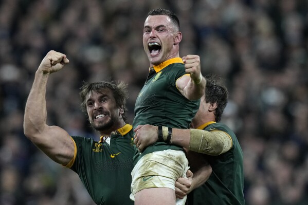 South Africa's Jesse Kriel, center, and South Africa's Eben Etzebeth celebrate after the Rugby World Cup final match between New Zealand and South Africa at the Stade de France in Saint-Denis, near Paris Saturday, Oct. 28, 2023. South Africa won the match 12-11. (AP Photo/Thibault Camus)