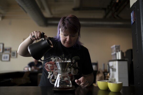 Renee Colon, co-owner of Fuego Coffee Roasters, makes a cup of coffee, Saturday, March 22, 2025, in Rochester, N.Y. (Max Conway via AP)