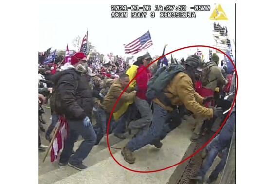 This image from police body-worn camera video, contained and annotated in the Justice Department's government's sentencing memorandum supporting the sentencing of Jeffrey Sabol shows Sabol at the U.S. Capitol on Jan. 6, 2021, in Washington. During the course of an attack on police officers, Sabol ripped the baton out of the hands of a fallen officer, leaving him unable to defend himself against assaults by other rioters. Sabol then helped his co-defendants drag a second officer into the crowd, where that officer was also beaten by rioters. (Department of Justice via AP)