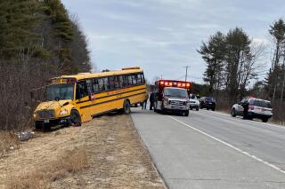 This photo provided by the Topsham Police Department shows a school bus that students steered to safety after the 77-year-old male driver suffered a medical event that left him incapacitated, Monday, March 14, 2022, in Topsham, Maine. The driver, Arthur McDougall, died later that day. Two students assisted in stopping the bus while a third student attempted to administer first aid. (Topsham Police Department via AP)