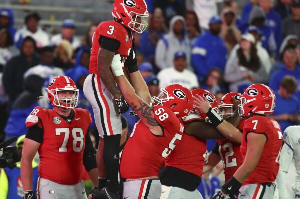 Georgia running back Andrew Paul gets a hoist from offensive lineman Austin Blaske after scoring a touchdown against Kentucky during the fourth quarter of an NCAA college football game Saturday, Oct. 7, 2023, in Athens, Ga. (Curtis Compton/Atlanta Journal-Constitution via AP)