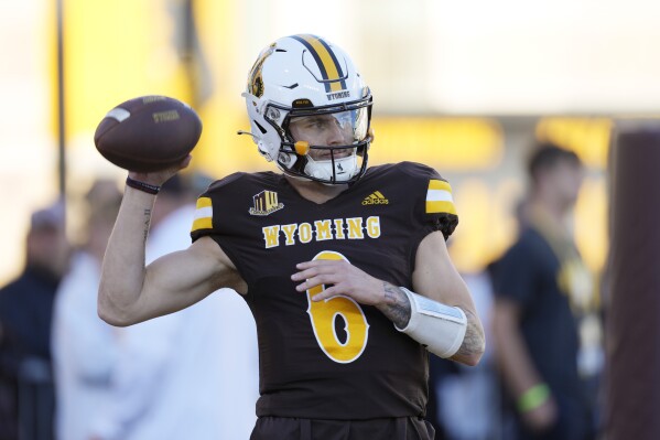 Wyoming quarterback Andrew Peasley warms up for the team's NCAA college football game against Fresno State on Saturday, Oct. 7, 2023, in Laramie, Wyo. (AP Photo/David Zalubowski)