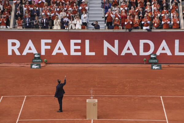 Rafa Nadal saluda a la multitud durante una ceremonia de despedida en la cancha central Philippe-Chatrier, en el estadio Roland-Garros, en París, el domingo 25 de mayo de 2025 (Foto AP/Thibault Camus)