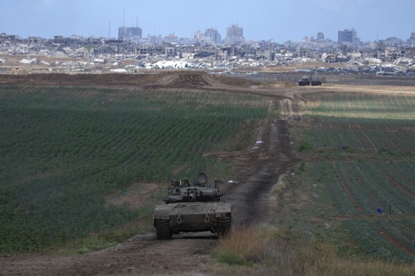 An Israeli Defense Forces tank drives away from the Gaza Strip, as seen from southern Israel, Monday, May 6, 2024. (AP Photo/Tsafrir Abayov)