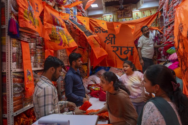 People buy flags of Hindu Lord Ram from a local shop in Mumbai, India, Tuesday, Jan. 16, 2024, ahead of the opening of the grand temple for the Lord Ram, Hinduism's most revered deities in Ayodhya on Jan.22, 2024. (AP Photo/Rafiq Maqbool)