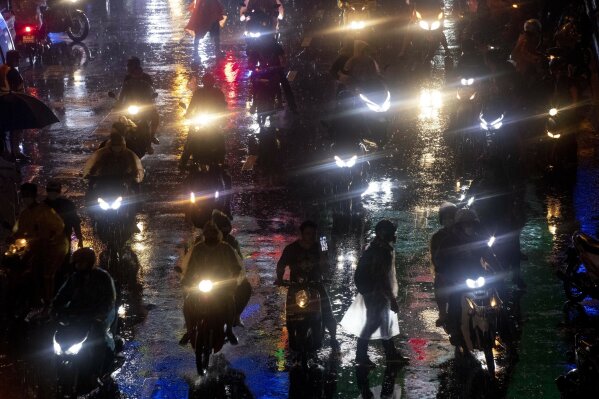 Pro-democracy demonstrators travel on motorcycles after ending their protest for the day in Bangkok, Thailand, Friday, Oct. 16, 2020. Thailand prime minister has rejected calls for his resignation as his government steps up efforts to stop student-led protesters from rallying in the capital for a second day in defiance of a strict state of emergency. (AP Photo/Gemunu Amarasinghe)