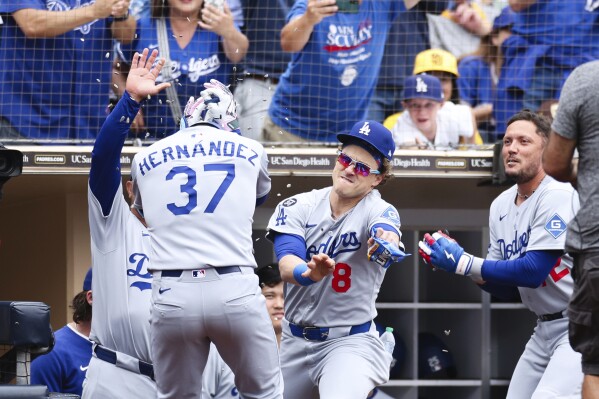 Los Angeles Dodgers' Teoscar Hernandez (37) has sunflower seeds thrown at him by Kiké Hernandez, center, and Robert Van Scoyoc, right, after Hernandez hit a three-run home run against the San Diego Padres in the fifth inning of a baseball game Wednesday, June 11, 2025, in San Diego. (AP Photo/Derrick Tuskan)