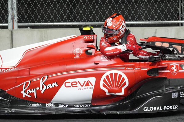 Ferrari driver Carlos Sainz, of Spain, climbs out of his car after stopping on the track during the first practice session for the Formula One Las Vegas Grand Prix auto race, Thursday, Nov. 16, 2023, in Las Vegas. (AP Photo/Nick Didlick)