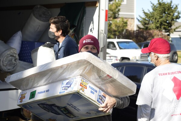 Team Rubicon volunteer Nicholas Duchnowski of Broomfield, Colo., moves belongings into an apartment that will be home to Afghan refugees, in the north Denver suburb of Thornton, Colo., Nov. 10, 2021. (AP Photo/David Zalubowski, Filepronto)