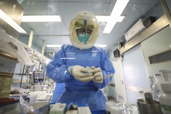 Medical staff work in the negative-pressure isolation ward in Jinyintan Hospital, designated for critical COVID-19 patients, in Wuhan in central China's Hubei province Thursday, Feb. 13, 2020. China on Thursday reported 254 new deaths and a spike in virus cases of 15,152, after the hardest-hit province of Hubei applied a new classification system that broadens the scope of diagnoses for the outbreak, which has spread to more than 20 countries. (Chinatopix Via AP)