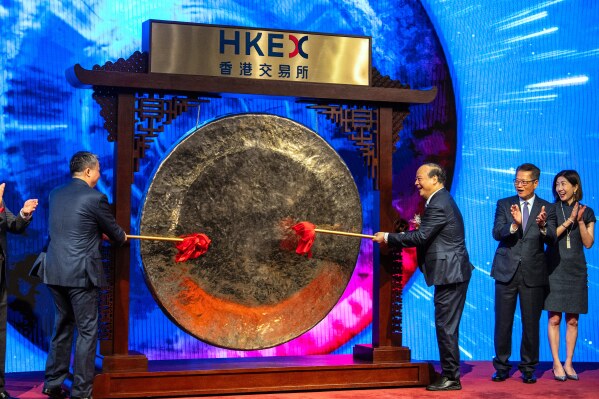Robin Zeng, chairman of Contemporary Amperex Technology Co. (CATL), center right, strikes the gong at the listing ceremony in Hong Kong, Tuesday, May. 20, 2025. (AP Photo/Chan Long Hei)