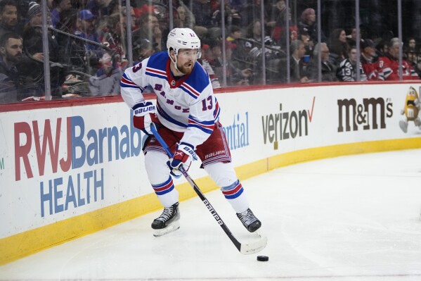 FILE - New York Rangers' Alexis Lafrenière skates with the puck during the second period of an NHL hockey game against the New Jersey Devils on March 30, 2023, in Newark, N.J. The Rangers have signed Lafrenière to a two-year contract worth $4.65 million, according to his agent, Wednesday, Aug. 23. He'll count just over $2.3 million against the salary cap each of the next two seasons. (AP Photo/Frank Franklin II, File)