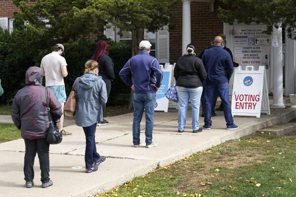 Cook County, Ill., residents wait in line for early voting and other county services Tuesday, Oct. 13, 2020, at a county courthouse in Maywood, Ill. (AP Photo/Charles Rex Arbogast)