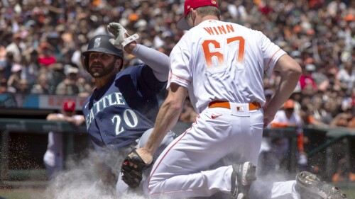 Seattle Mariners' Mike Ford (20) scores from third on a passed ball ahead of the tag by San Francisco Giants starting pitcher Keaton Winn (67) during the second inning of a baseball game, Tuesday, July 4, 2023, in San Francisco. (AP Photo/D. Ross Cameron)