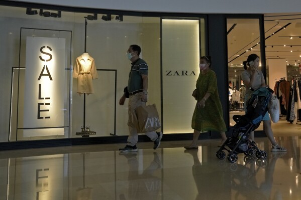 FILE - A man with a shopping bag walks out from a ZARA flagship store at a shopping mall in Beijing, on June 21, 2023. American companies operating in China view tensions with Washington over technology, trade and other issues as a major hindrance for their businesses there, according to a survey by the American Chamber of Commerce in Shanghai. (AP Photo/Andy Wong, File)
