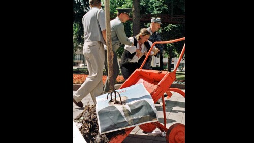FILE - Belarusian security officers detain Ales Pushkin, an artist and opposition activist, after he brought a wheelbarrow filled with manure and dumped it in front of President Alexander Lukashenko's office in Minsk, Belarus, July 21, 1999. The Belarusian artist has died in a prison, where he was serving a five-year sentence, human rights activists and his wife said Tuesday July 11, 2023 (AP Photo/File)