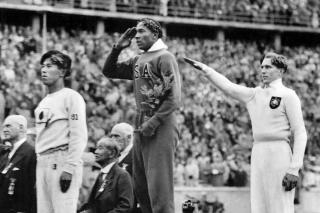 FILE - In this Aug. 11, 1936, file photo, America's Jesse Owens, center, salutes during the presentation of his gold medal for the long jump, alongside silver medalist Luz Long, right, of Germany, and bronze medalist Naoto Tajima, of Japan, during the 1936 Summer Olympics in Berlin. The silver medal captured by Luz Long, the German long jumper who befriended Jesse Owens at the 1936 Olympics in Berlin, sold at auction for $488,000, a sum the auction house said was a record price for a publicly sold second-place prize.  (AP Photo/File)