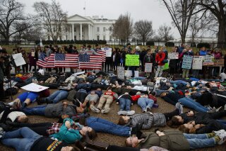 
              Demonstrators participate in a "lie-in" during a protest in favor of gun control reform in front of the White House, Monday, Feb. 19, 2018, in Washington. (AP Photo/Evan Vucci)
            
