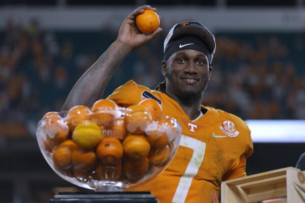Tennessee quarterback Joe Milton III (7) throws oranges from the trophy to teammates after Tennessee defeated Clemson in the Orange Bowl NCAA college football game, early Saturday, Dec. 31, 2022, in Miami Gardens, Fla. (AP Photo/Rebecca Blackwell)
