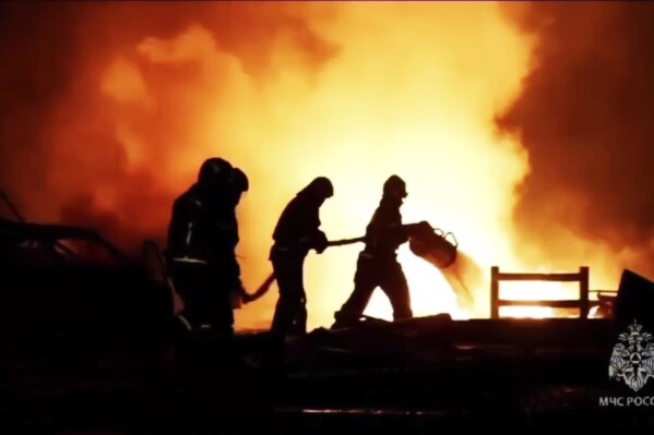 In this image made from video provided by the Russian Emergency Situations Ministry press service, firefighters work to extinguish a fire at a petrol station on a road near Makhachkala, the capital of Dagestan, Russia, late Monday, Aug. 14, 2023. (Ministry of Emergency Situations press service via AP)