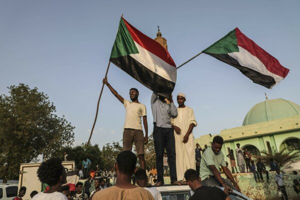 FILE - In this Friday, July 5, 2019, file photo, Sudanese people celebrate in the streets of Khartoum after ruling generals and protest leaders announced they have reached an agreement on the disputed issue of a new governing body. The power-sharing agreement reached between Sudan’s military and pro-democracy protesters last week came after the United States and its Arab allies applied intense pressure on both sides amid fears a prolonged crisis could tip the country into civil war, activists and officials said. (AP Photo/File)