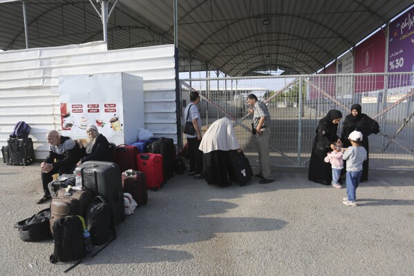 Palestinains wait at the border crossing between the Gaza Strip and Egypt, in Rafah, Wednesday, Nov. 1, 2023. (AP Photo/Hatem Ali)