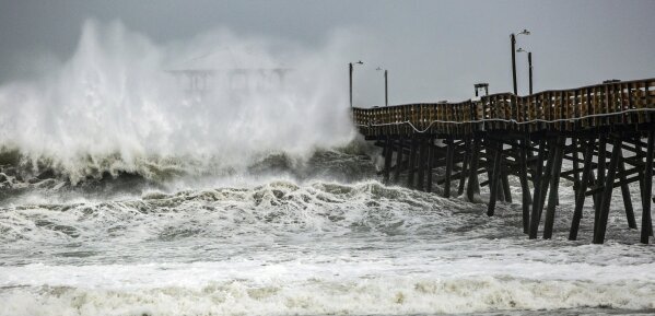 
              Waves slam the Oceana Pier & Pier House Restaurant in Atlantic Beach, N.C.,  Thursday, Sept. 13, 2018 as Hurricane Florence approaches the area.  (Travis Long /The News & Observer via AP)
            