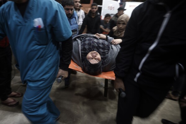 A wounded Palestinian woman is carried into the Nasser Hospital following an Israeli bombardment on Khan Younis refugee camp, southern Gaza Strip, Tuesday, Nov. 21, 2023. (AP Photo/Mohammed Dahman)