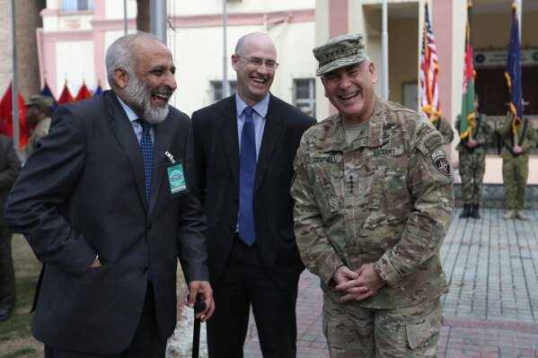 FILE - In this March 2, 2016, file photo, outgoing Commander of Resolute Support forces and United States forces in Afghanistan, U.S. Army General John Campbell, right, and Afghan head of Afghan government peace negotiating team Mohammad Masoom Stanikzai, left, laugh during a change of command ceremony in Resolute Support headquarters in Kabul, Afghanistan. After months of deliberation Afghan President Ashraf Ghani announced his 21-member team to negotiate peace with the Taliban, only to have his political opponent reject it Friday as not inclusive enough. (AP Photo/Rahmat Gul, File)