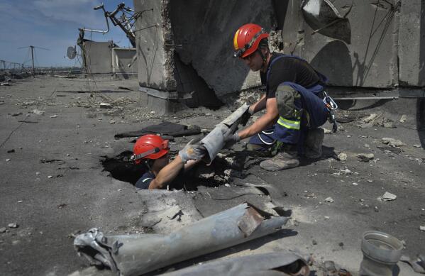 Ukrainian rescuers search for and retrieve the remains of Russian shells on the roof of a high-rise building damaged by Russian shelling in one of the residential areas of Kharkiv, Ukraine, Thursday, June 30, 2022. (AP Photo/Sofiia Bobok)