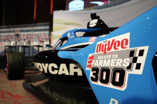 A Salute to Farmers 300 logo is seen on a car during a news conference at Hy-Vee Corp. headquarters, Thursday, Aug. 19, 2021, in West Des Moines, Iowa. IndyCar will return next season to Iowa Speedway, a short oval track beloved by fans and drivers that had fallen off the schedule after 14 years. The track located in Newton will host a doubleheader next July in a deal brokered between IndyCar Series owner Roger Penske, team owner Bobby Rahal and grocery chain Hy-Vee. (AP Photo/Charlie Neibergall)