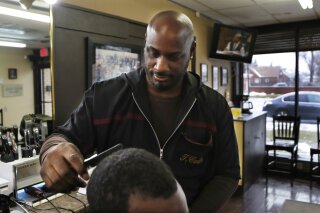 
              In this Thursday, Feb. 7, 2019 photo, barber Thomas Carter cuts a customer's hair in Detroit. Carter says there's nothing funny about blackface, calling it a "huge form of disrespect" to African Americans. Past uses of blackface as attempts to humor have clouded the political futures of two of Virginia's top leaders, while angering many African Americans who see it as part of America's painful history of racism, hate and exploitation. (AP Photo/Carlos Osorio)
            