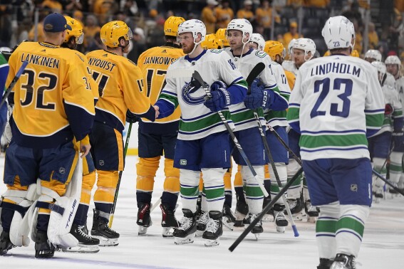 The Nashville Predators and Vancouver Canucks shake hands after Game 6 of an NHL hockey Stanley Cup first-round playoff series Friday, May 3, 2024, in Nashville, Tenn. The Canucks won 1-0 winning the series four games to two. (AP Photo/George Walker IV)