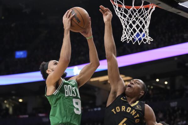 Boston Celtics guard Derrick White (9) goes up for a basket as Toronto Raptors forward Scottie Barnes (4) defends during second-half NBA basketball game action in Toronto, Saturday, Jan. 21, 2023. (Frank Gunn/The Canadian Press via AP)