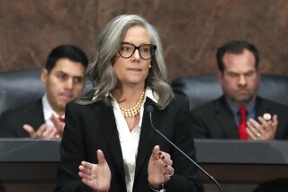 Arizona Democratic Gov. Katie Hobbs, center, applauds for those affected by the Los Angeles area wildfires as she gives the State of the State address in the House of Representatives at the Capitol with Speaker of the House Rep. Steve Montenegro, R-Litchfield Park, left, and Senate President Warren Petersen, R-Gilbert, flanking the governor on Jan. 13, 2025, in Phoenix. (AP Photo/Ross D. Franklin, File)