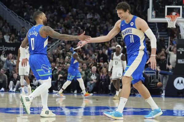 Milwaukee Bucks' Damian Lillard and Brook Lopez celebrate during the first half of an NBA basketball game Thursday, March 21, 2024, in Milwaukee. (AP Photo/Morry Gash)