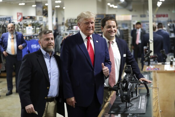Former President Donald Trump visits the Palmetto State Armory and takes a picture with owners Jamin McCallum and Julian Wilson in Summerville, S.C., Monday, Sept. 25, 2023. (AP Photo/Artie Walker Jr.)