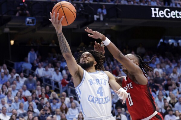 North Carolina guard RJ Davis (4) drives to the basket against North Carolina State guard DJ Horne (0) during the first half of an NCAA college basketball game Saturday, March. 2, 2024, in Chapel Hill, N.C. (AP Photo/Chris Seward)