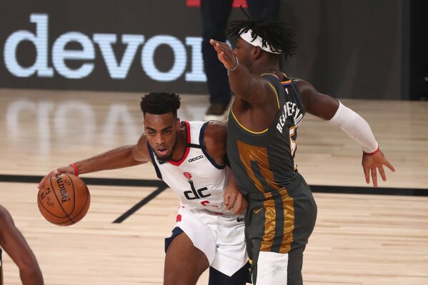 Washington Wizards forward Troy Brown Jr., left, drives against Oklahoma City Thunder guard Luguentz Dort, right, during the first half of an NBA basketball game Sunday, Aug. 9, 2020, in Lake Buena Vista, Fla. (Kim Klement/Pool Photo via AP)