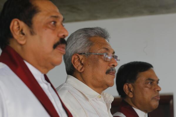 FILE - Sri Lanka's former president Mahinda Rajapaksa, left, along with his brothers former defense secretary Gotabaya Rajapaksa, center, and former economics development minister Basil Rajapaksa, attend a meeting at their party office with local politicians in Colombo, Sri Lanka,  July 4, 2018. With one brother president, another prime minister and three more family members cabinet ministers, it appeared that the Rajapaksa clan had consolidated its grip on power in Sri Lanka after decades in and out of government. With a national debt crisis spiraling out of control, it looks like the dynasty is nearing its end with Prime Minister Mahinda stepping down on Monday, May 9, 2022, and the three Rajapaksas resigning their cabinet posts in April, but the family is not going down without a fight. (AP Photo/Eranga Jayawardena, File)