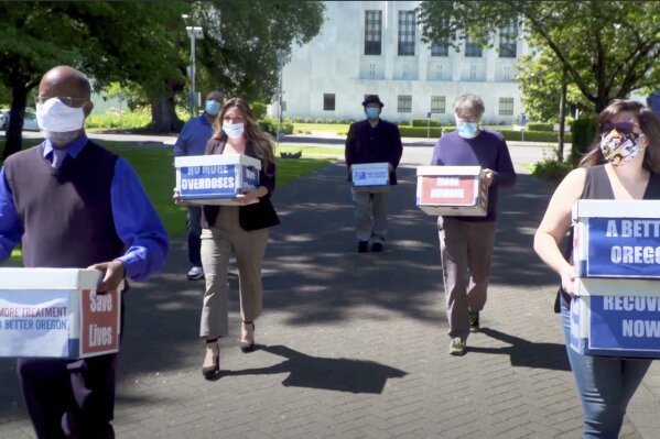 FILE - This June 26, 2020 file photo from video provided by the Yes on Measure 110 Campaign shows volunteers delivering boxes containing signed petitions in favor of the measure to the Oregon Secretary of State's office in Salem.  The measure said the U.S., possession of small amounts of heroin, cocaine, LSD and other hard drugs would be decriminalized in Oregon. Election returns show the measure passed on Election Day, Tuesday, Nov. 3. (Yes on Measure 110 Campaign via AP, File)