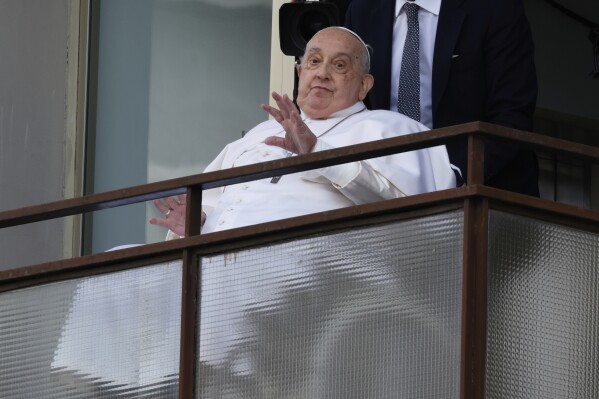 Pope Francis appears at a window of the Agostino Gemelli Polyclinic in Rome, Sunday, March 23, 2025, where he has been treated for bronchitis and bilateral pneumonia since Feb. 14. (AP Photo/Riccardo De Luca)