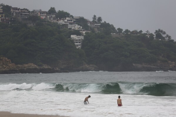 FILE - Tourists swim in Acapulco, Mexico, Oct. 24, 2023. Hurricane Otis turned from mild to monster in record time, and scientists are struggling to figure out how — and why they didn't see it coming. (AP Photo/Bernardino Hernandez, File)