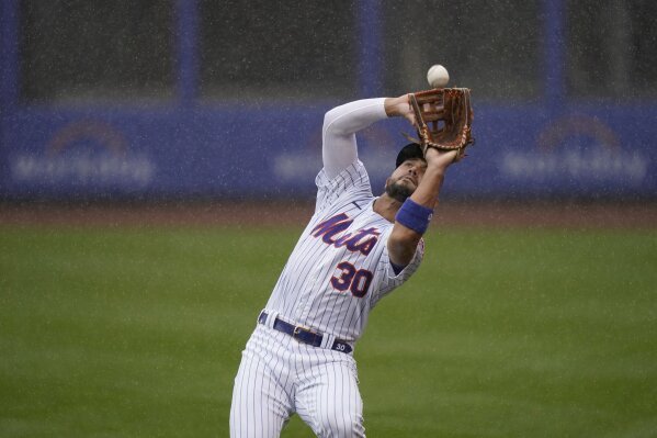 New York Mets right fielder Michael Conforto catches a fly ball in the rain during the first inning of a baseball game at Citi Field, Sunday, April 11, 2021, in New York. The game was delayed at the top of the first inning due to rain. (AP Photo/Seth Wenig)