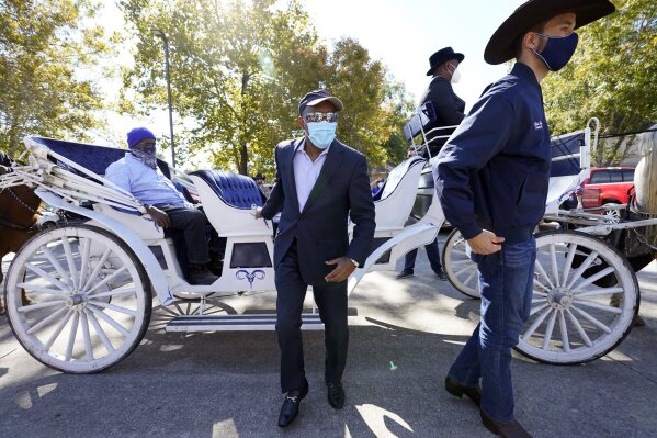 Houston Mayor Sylvester Turner, center, and Harris County Clerk Chris Hollins, right, arrive a voting site Tuesday, Nov. 3, 2020, in Houston. (AP Photo/David J. Phillip)