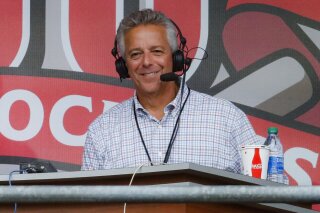 FILE - In this Sept. 25, 2019, file photo, Cincinnati Reds broadcaster Thom Brennaman sits in a special outside booth before the Reds' baseball game against the Milwaukee Brewers in Cincinnati. Brennaman used a gay slur during the broadcast of Cincinnati's game against the Kansas City Royals on Wednesday, Aug. 19, 2020. Brennaman used the slur moments after the Fox Sports Ohio broadcast returned from a commercial break before the seventh inning in the first game of a doubleheader. Brennaman did not seem to realize he was already on air. (AP Photo/John Minchillo, File)